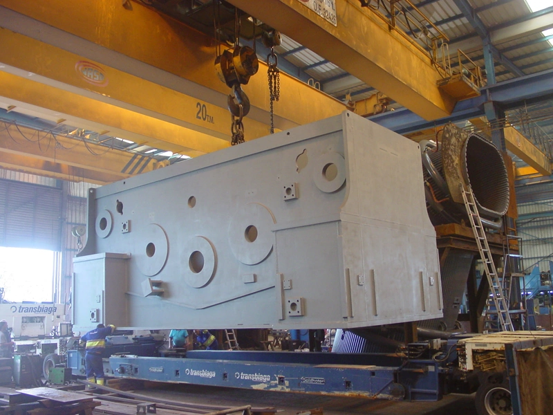 Large metal assembly lifted by overhead cranes
